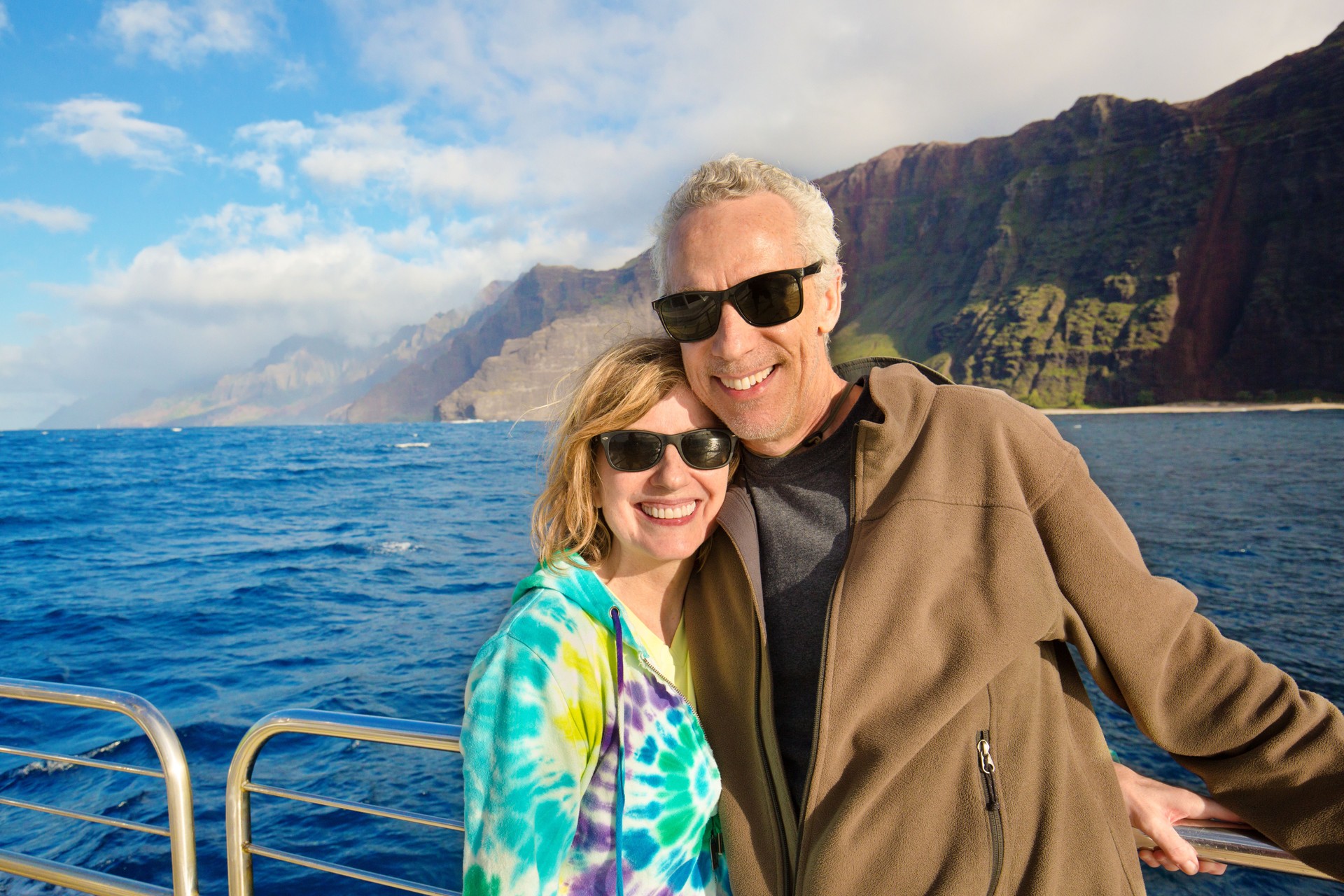 Tourist couple enjoying a boutique cruise along the Na Pali Coast in Kauai, Hawaii—highlighting the personalized, luxury cruise experiences curated by Curated Passports.