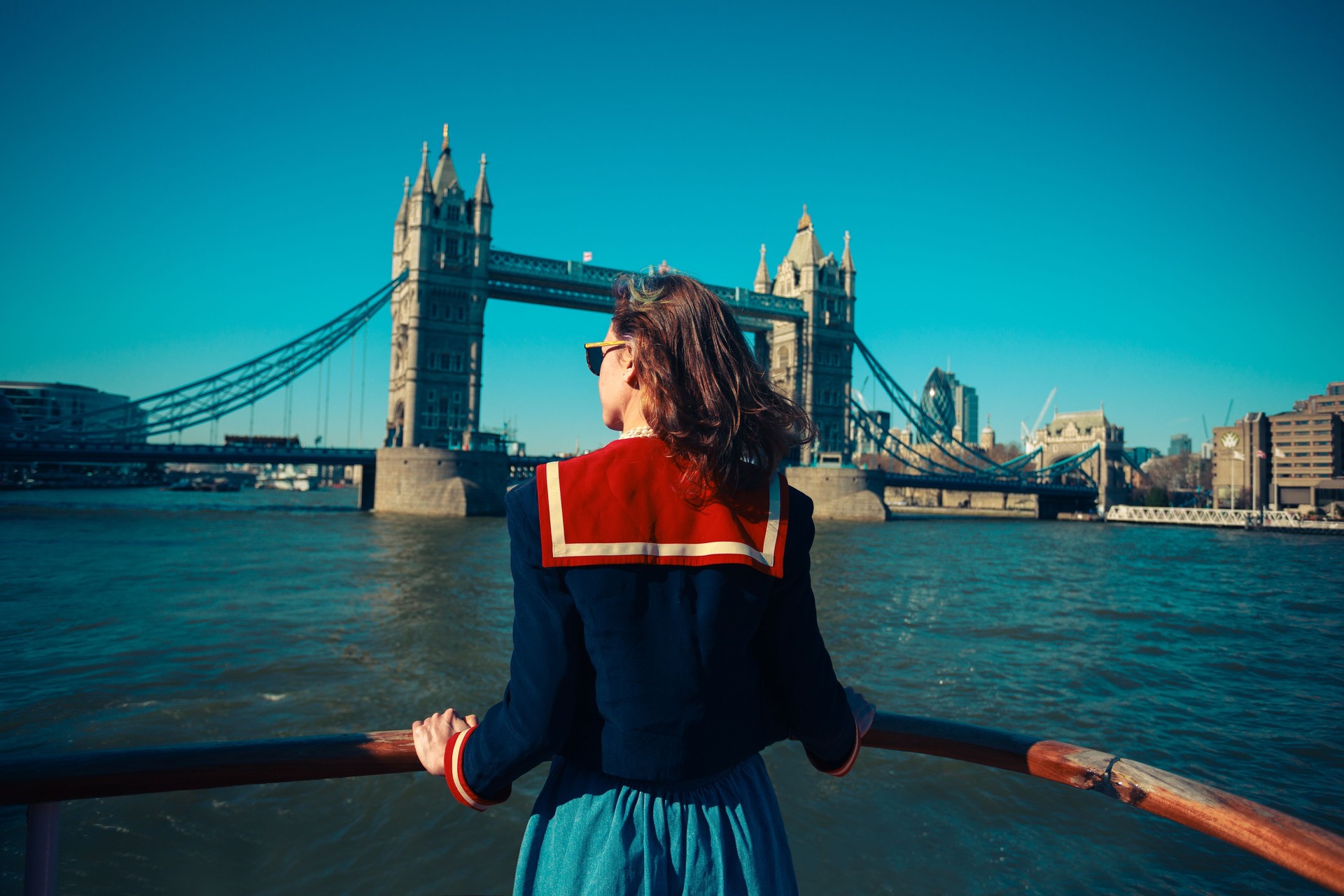 Young woman on boat looking at Tower Bridge in London