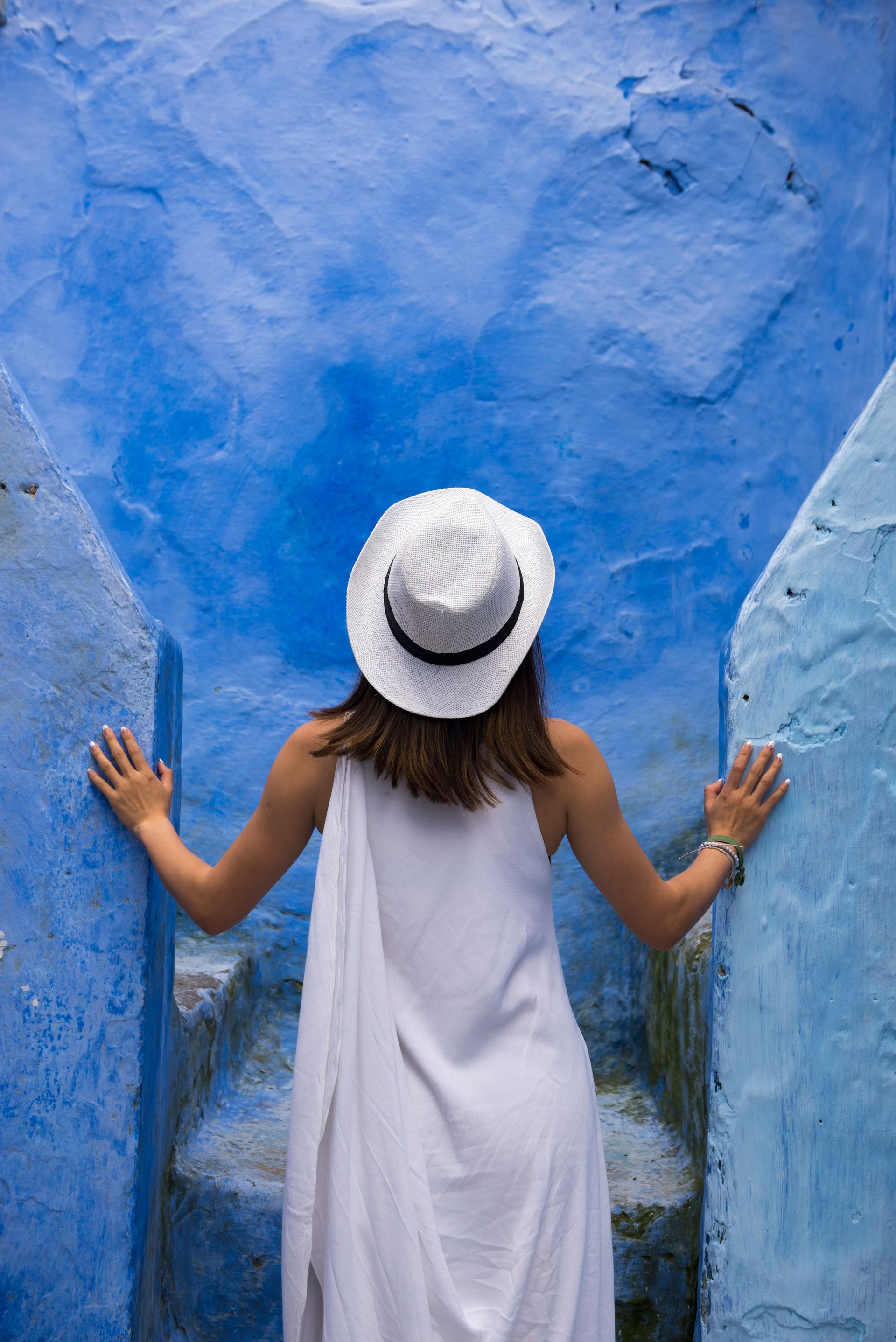 Traveler exploring the vibrant blue streets of Chefchaouen, Morocco—an example of the immersive, culturally rich journeys curated by Curated Passports.